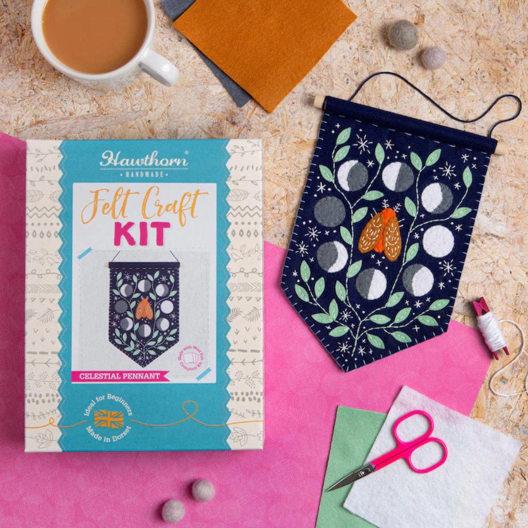 Moonlight felt wall hanging craft kit displayed alongside the completed project and craft supplies