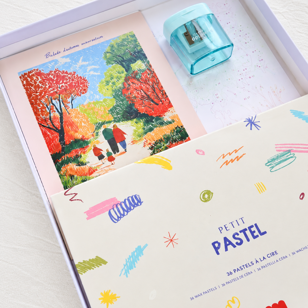 Autumn Stroll Pastels By Numbers Kit by La Petite Epicerie showing the illustrated artwork, colourful wax pastels, sharpener and accompanying materials.