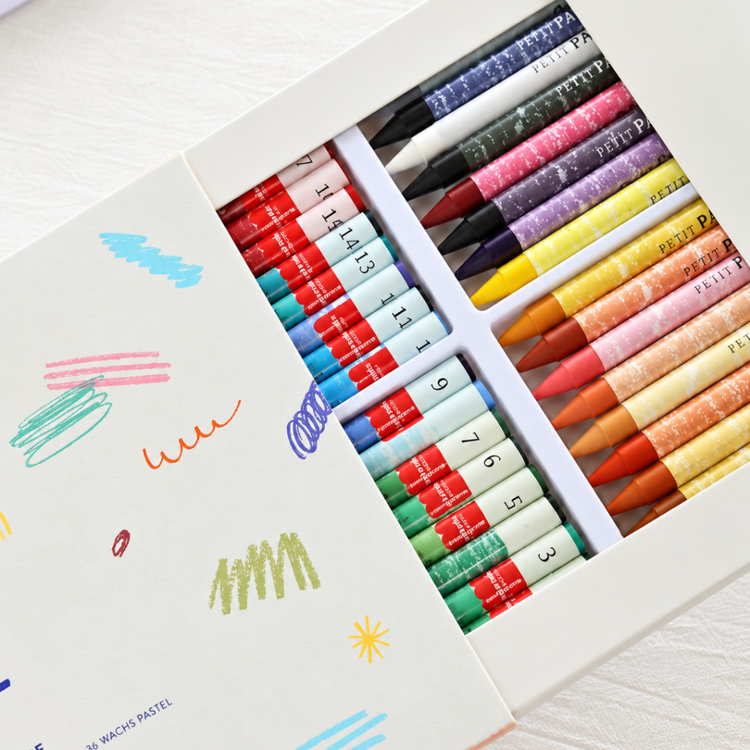 Box of colourful wax pastels arranged beside a practice sheet with pastel colour samples for the Autumn Stroll Pastels By Numbers Kit.