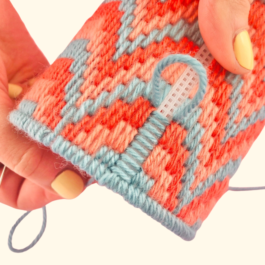 Close-up of colourful bargello needlepoint stitching in progress, highlighting the geometric pattern, canvas and vibrant wool included in the kit.