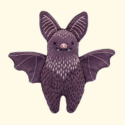 Finished Bat Embroidery Kit doll with outstretched wings and textured purple stitching by Kiriki Press.