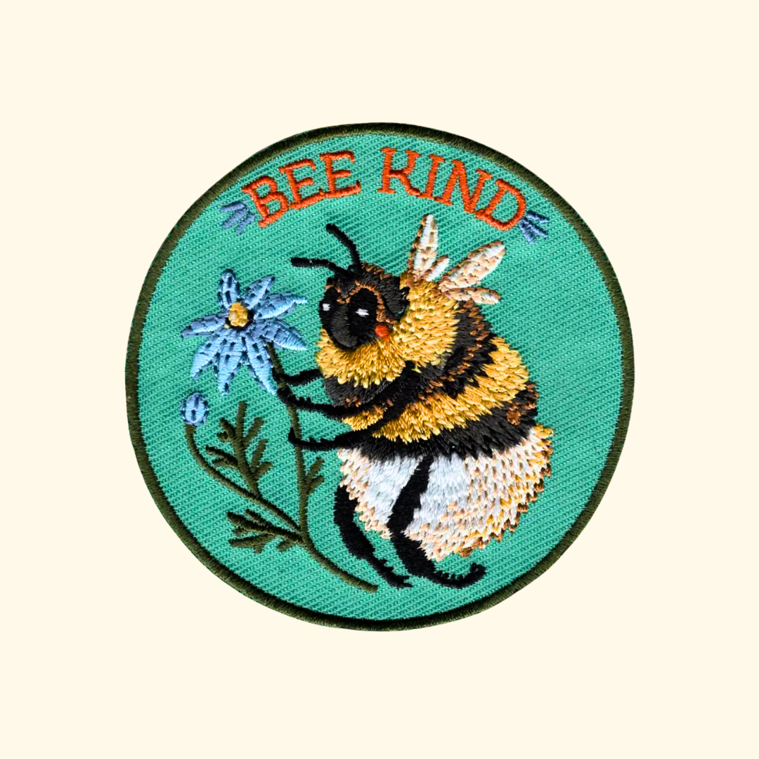 Bee Kind embroidered iron on patch by Anna Seed Art featuring a bumblebee with the words "Bee Kind".