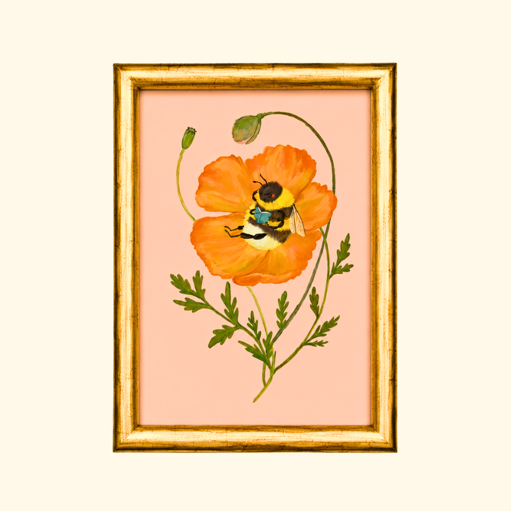 Beebliophile greeting card displayed in a gold frame, showcasing the whimsical illustration of a bee reading a book inside a blooming orange poppy.
