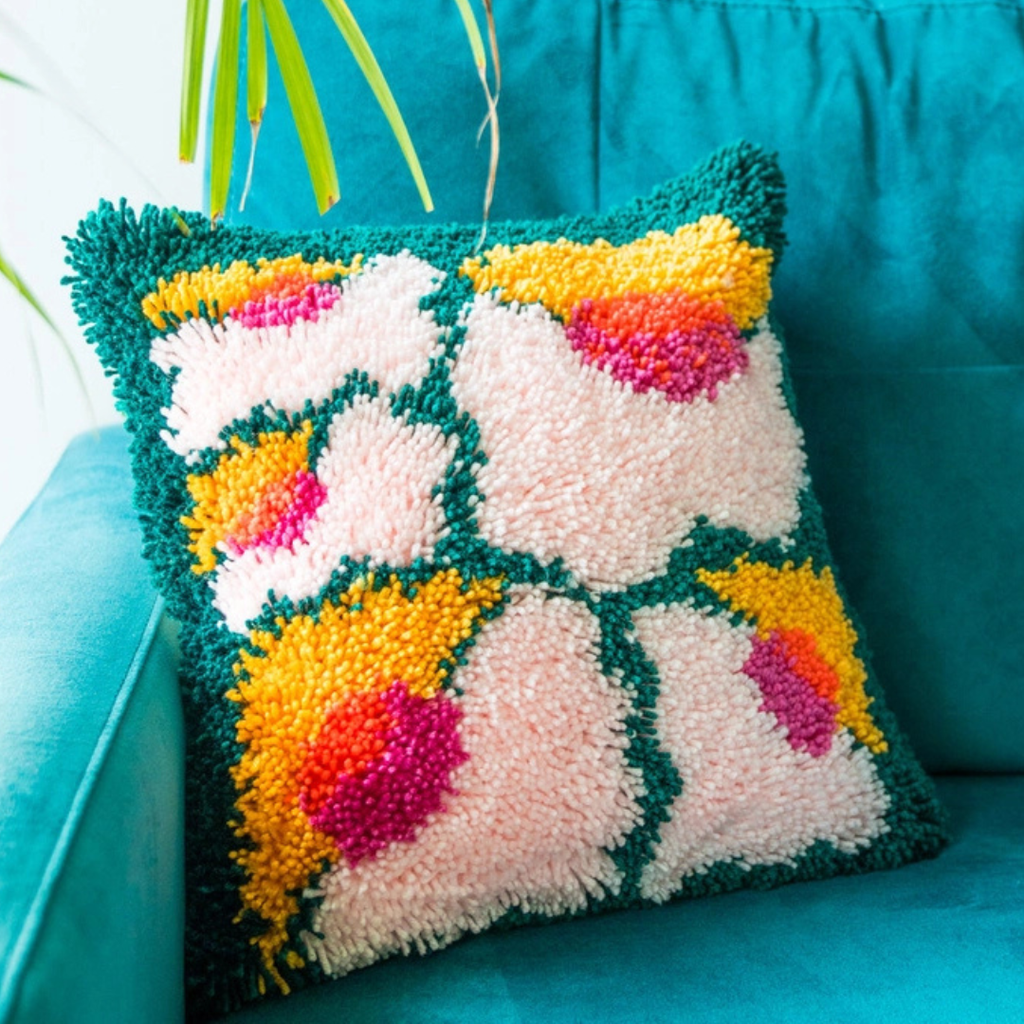 Close-up of the completed Bloomin Lovely latch hook cushion showing the soft textured yarn and floral pattern.