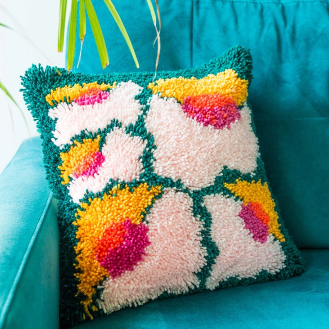 Close-up of the completed Bloomin Lovely latch hook cushion showing the soft textured yarn and floral pattern.