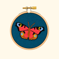 Finished Butterfly Mini Embroidery Kit by Paraffle displayed in a wooden embroidery hoop.