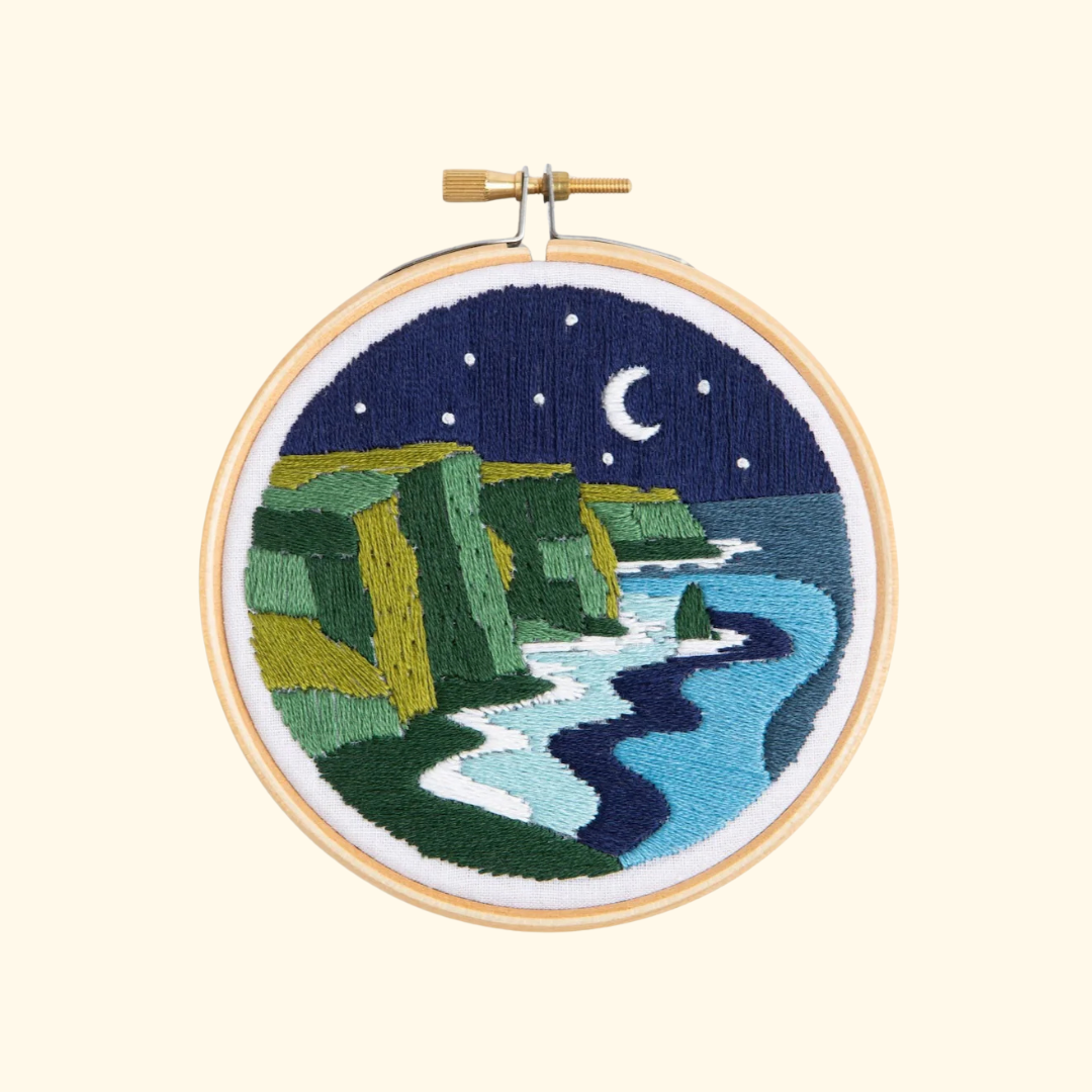 Celtic Cliffs Mini Embroidery Kit by Hawthorn Handmade featuring a moonlit coastal landscape with green cliffs, ocean and night sky embroidery.