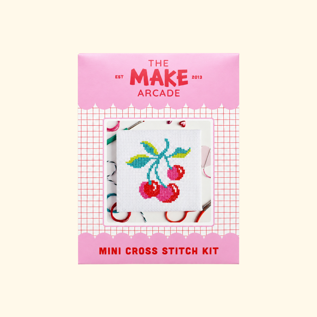 The Make Arcade Cherries Mini Cross Stitch Kit in pink packaging.