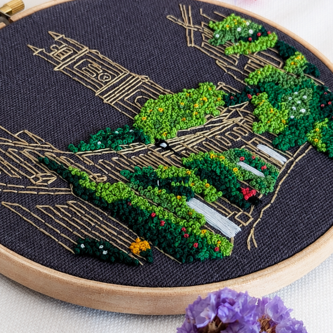 Close-up angled view of the embroidered Circus Lane buildings and greenery on dark fabric.