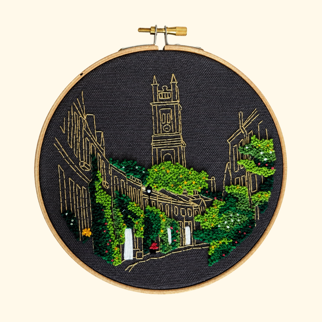 Finished Circus Lane Embroidery Kit by Paraffle displayed in a wooden embroidery hoop.