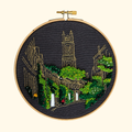 Finished Circus Lane Embroidery Kit by Paraffle displayed in a wooden embroidery hoop.