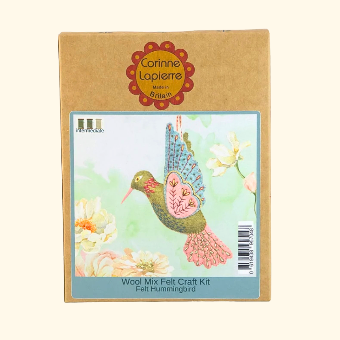 A cardboard box for a Corinne Lapierre felt hummingbird craft kit, featuring a colorful illustration of a felt hummingbird on the front label.