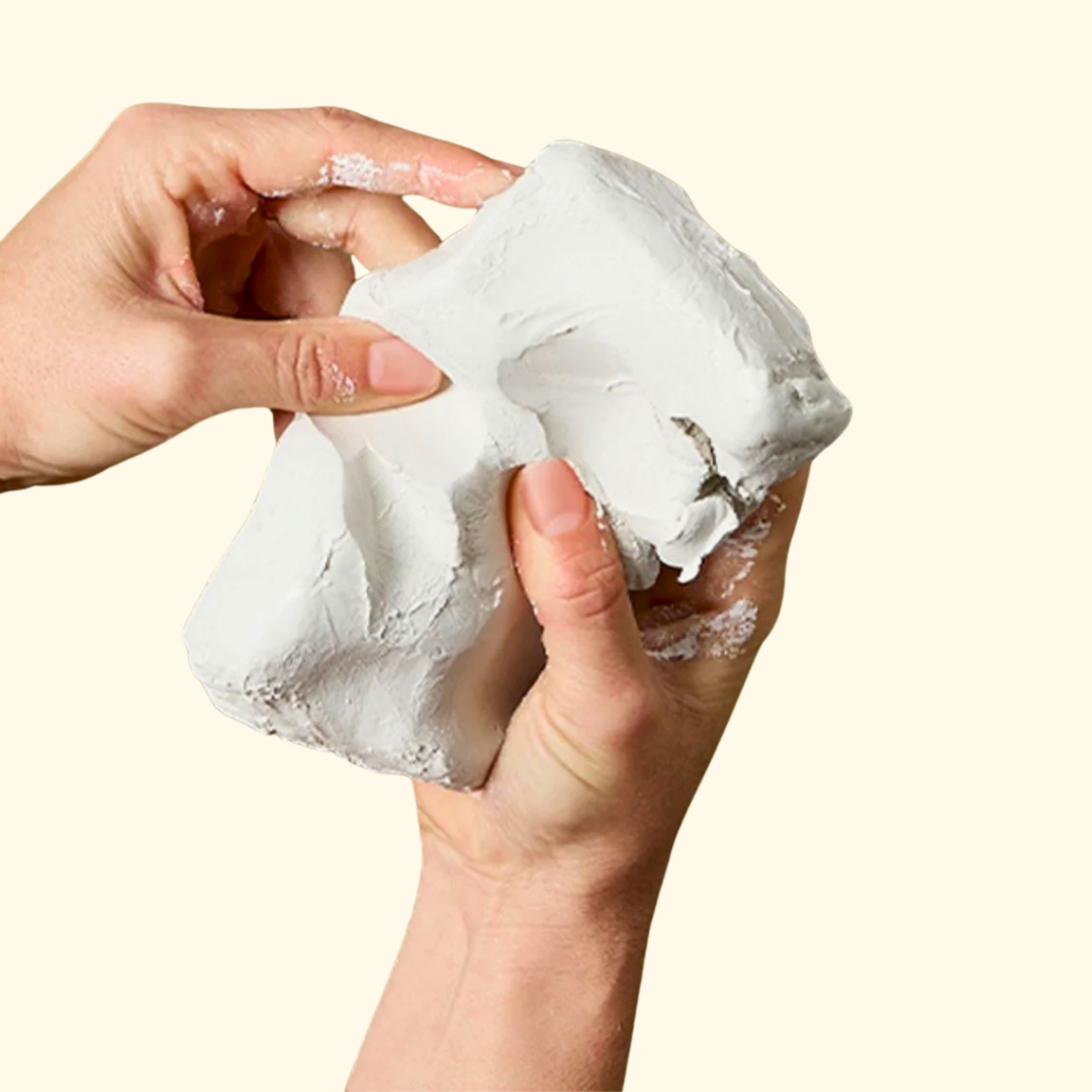 Hands stretching soft air dry clay for pottery making