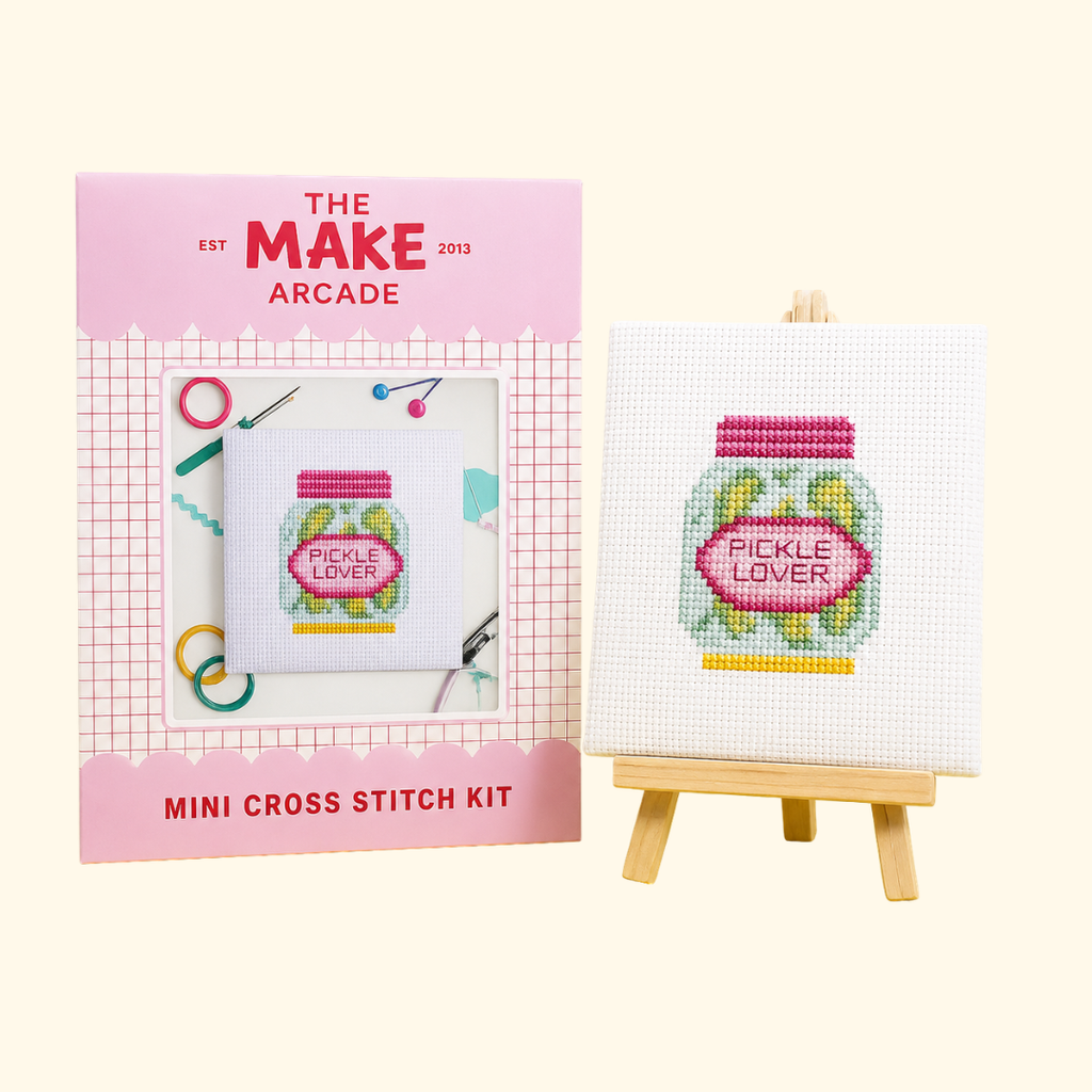 Dill Pickle Mini Cross Stitch Kit by The Make Arcade with packaging and finished stitched design on a mini easel.