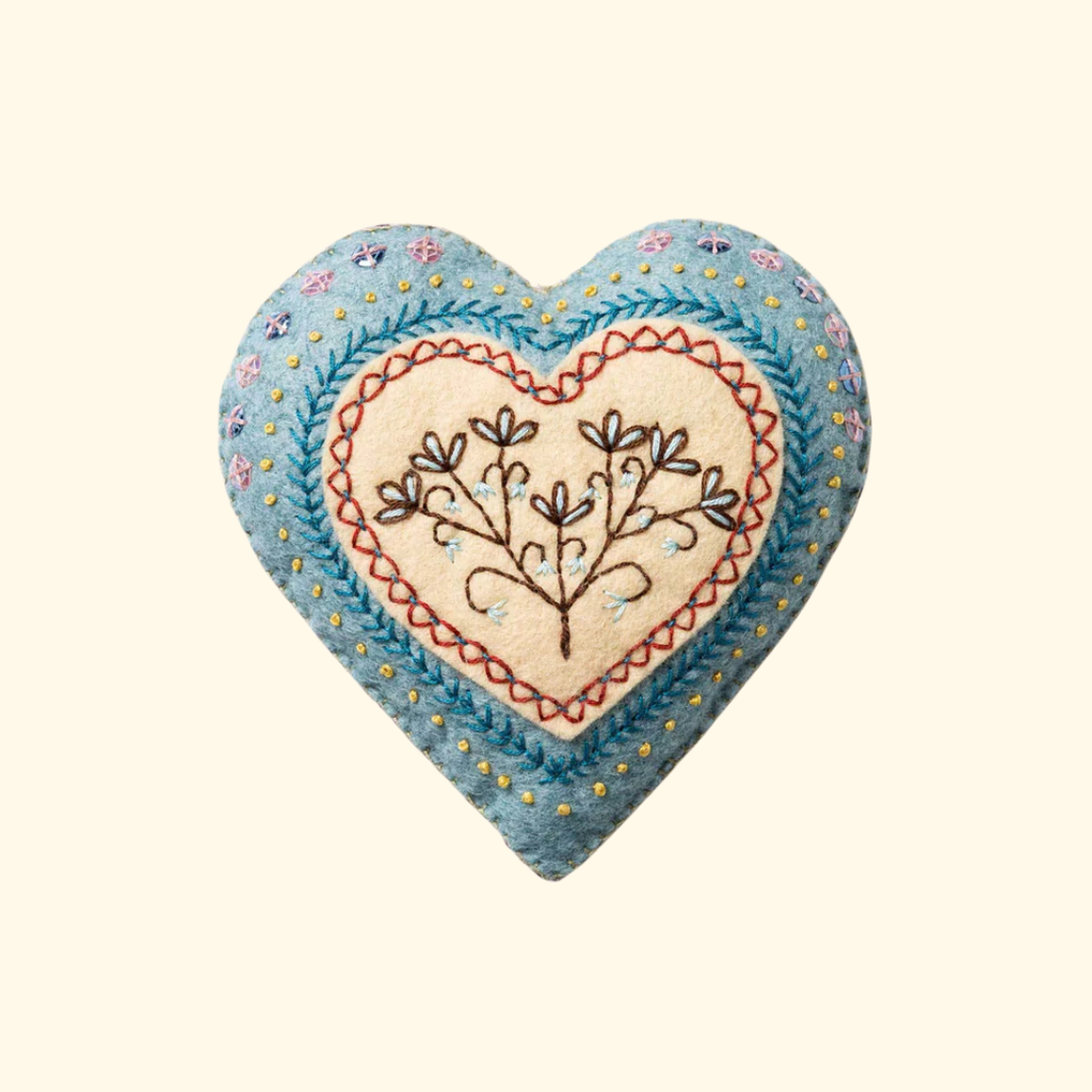 Finished embroidered heart felt craft kit by Corinne Lapierre displayed against a plain background.
