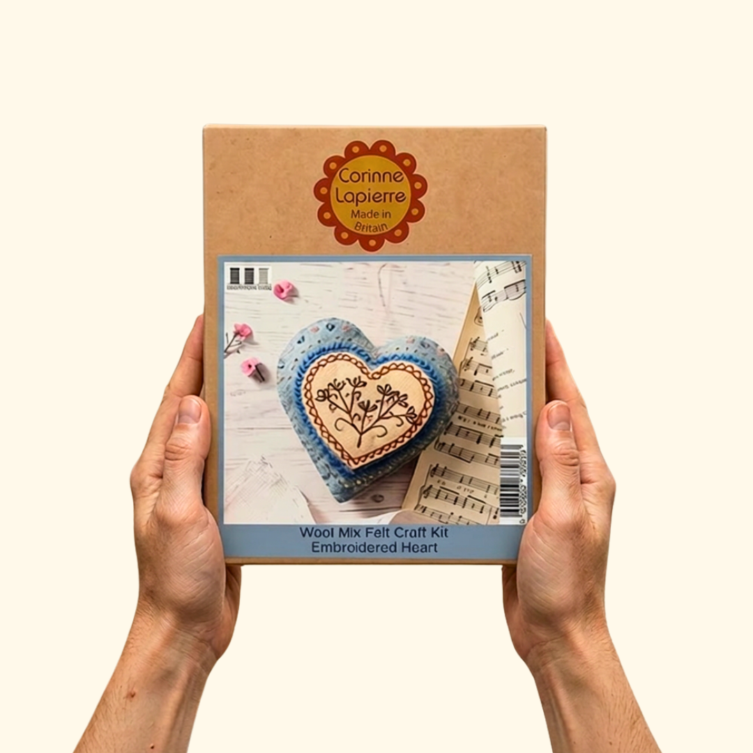 Person holding the Embroidered Heart felt craft kit packaging by Corinne Lapierre.