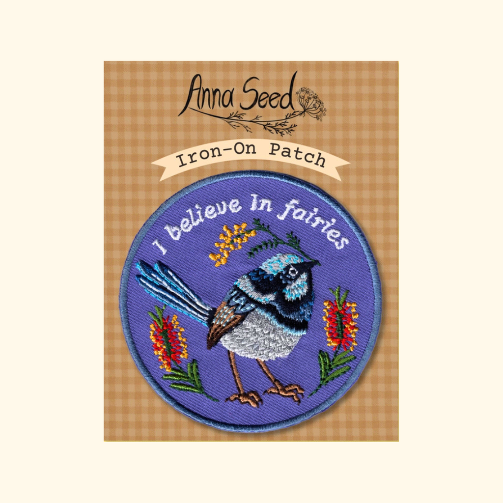 Packaged Fairy Wren embroidered iron on patch by Anna Seed Art displayed on its backing card.
