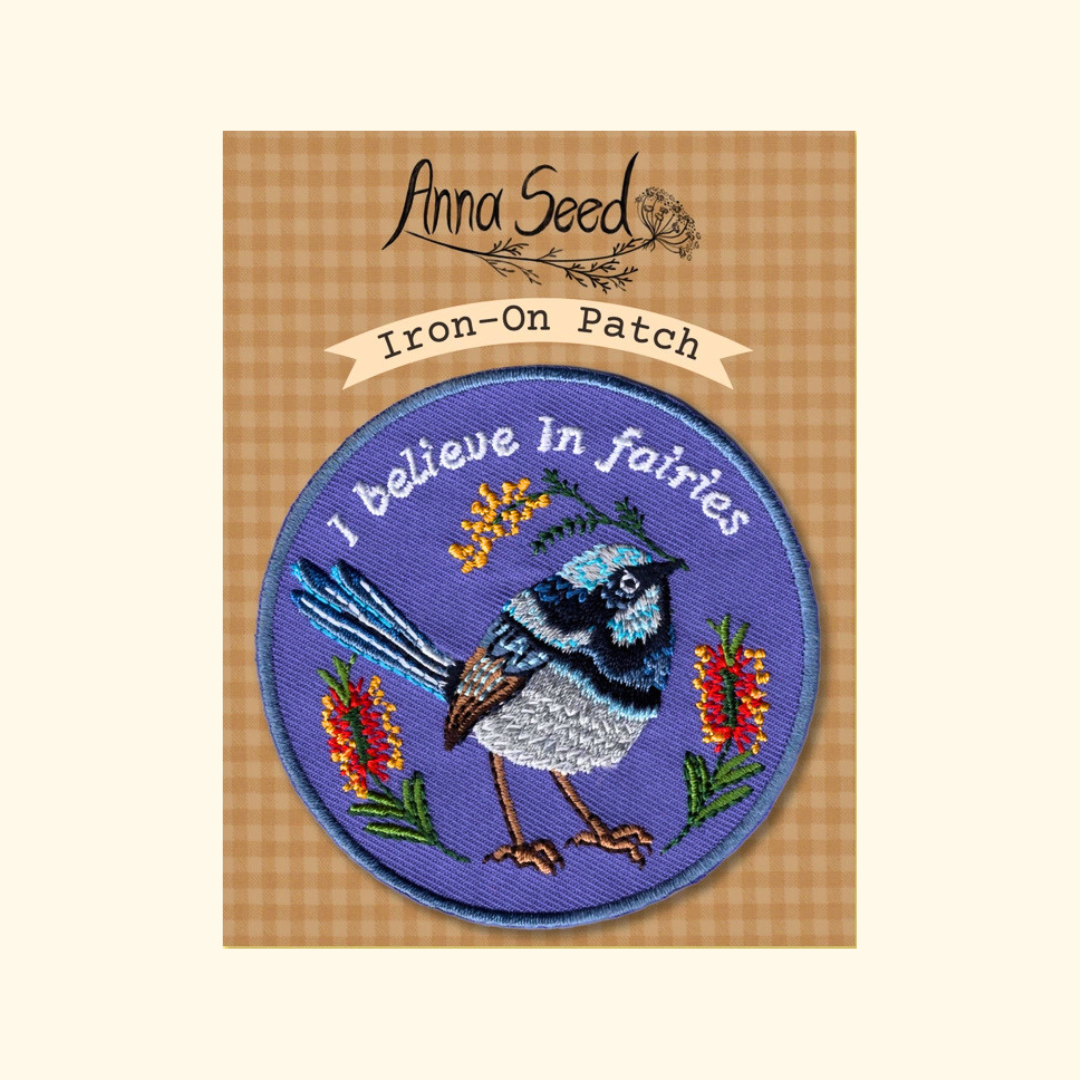 Packaged Fairy Wren embroidered iron on patch by Anna Seed Art displayed on its backing card.