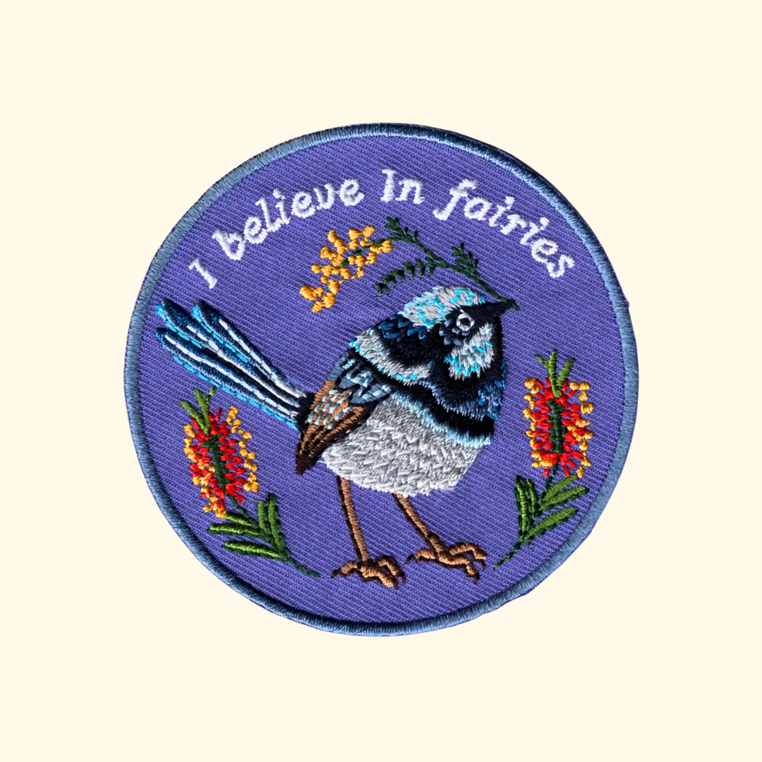 Fairy Wren embroidered iron on patch by Anna Seed Art featuring a blue fairy wren with the words "I Believe in Fairies".