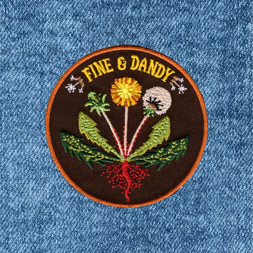 Fine & Dandy embroidered iron on patch by Anna Seed Art applied to blue denim fabric.