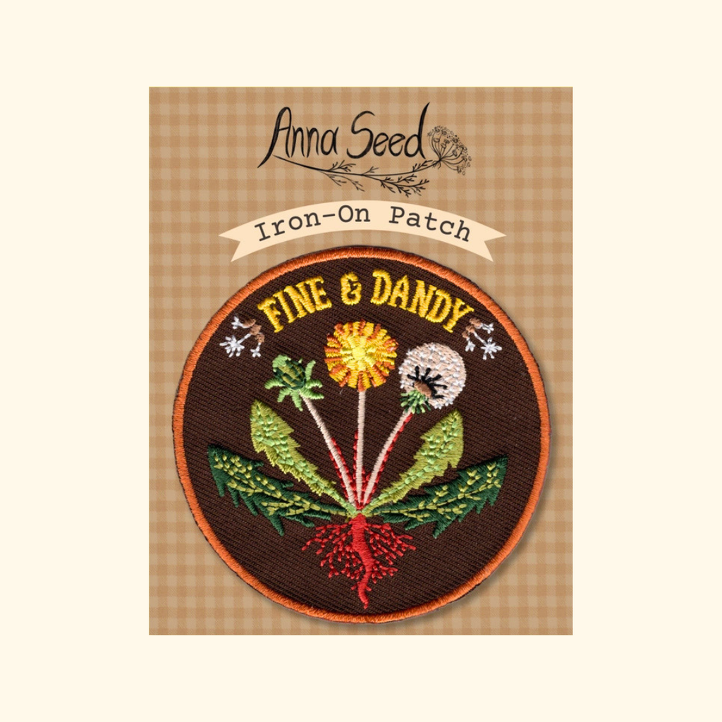 Packaged Fine & Dandy embroidered iron on patch by Anna Seed Art displayed on its backing card.