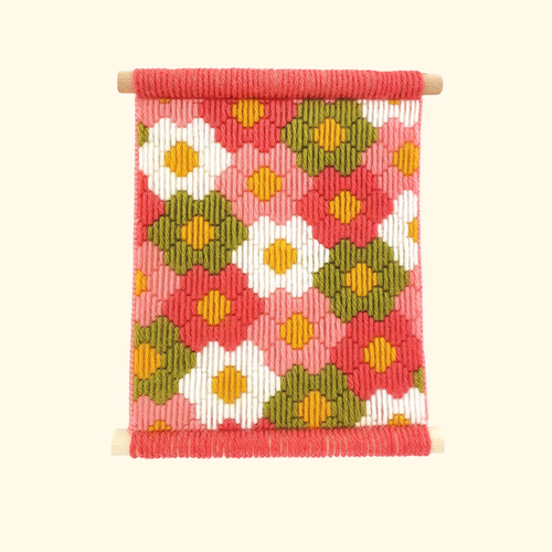 Completed Flower Power bargello wall hanging featuring colourful geometric floral motifs in pink, orange, mustard and green