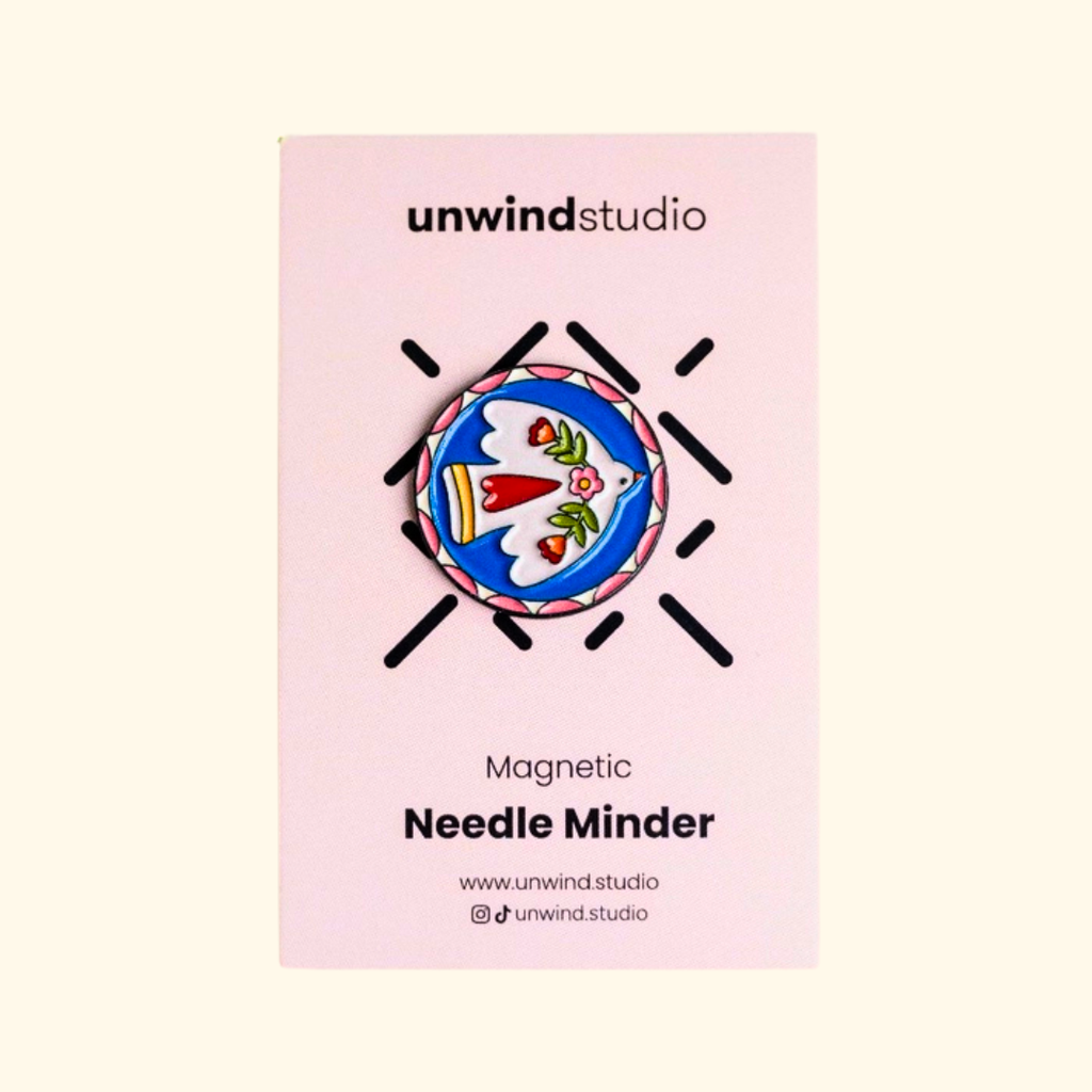 Folk Bird Magnetic Needle Minder by Unwind Studio displayed on its pink packaging card.