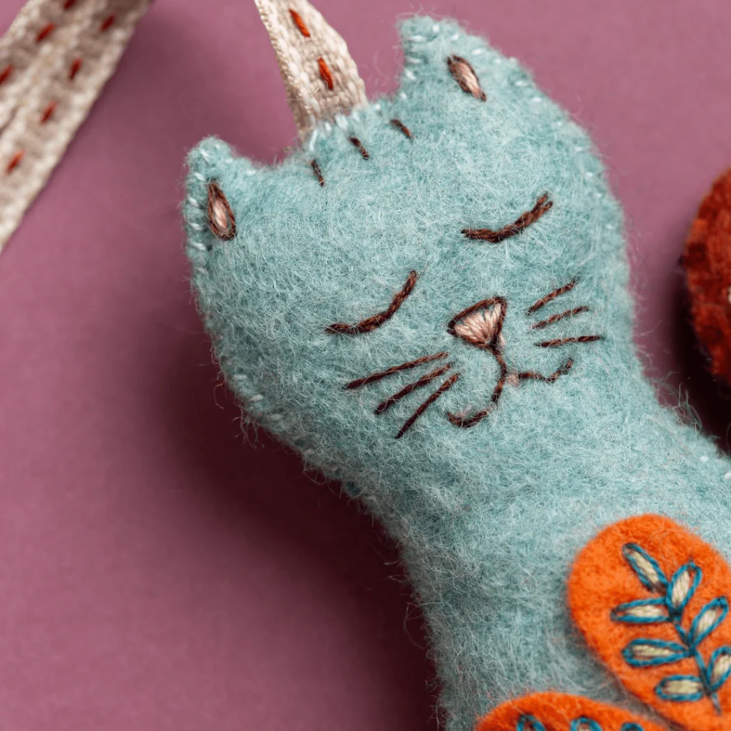 Close up of decorative embroidery stitching on the Folk Cat felt craft kit by Corinne Lapierre.