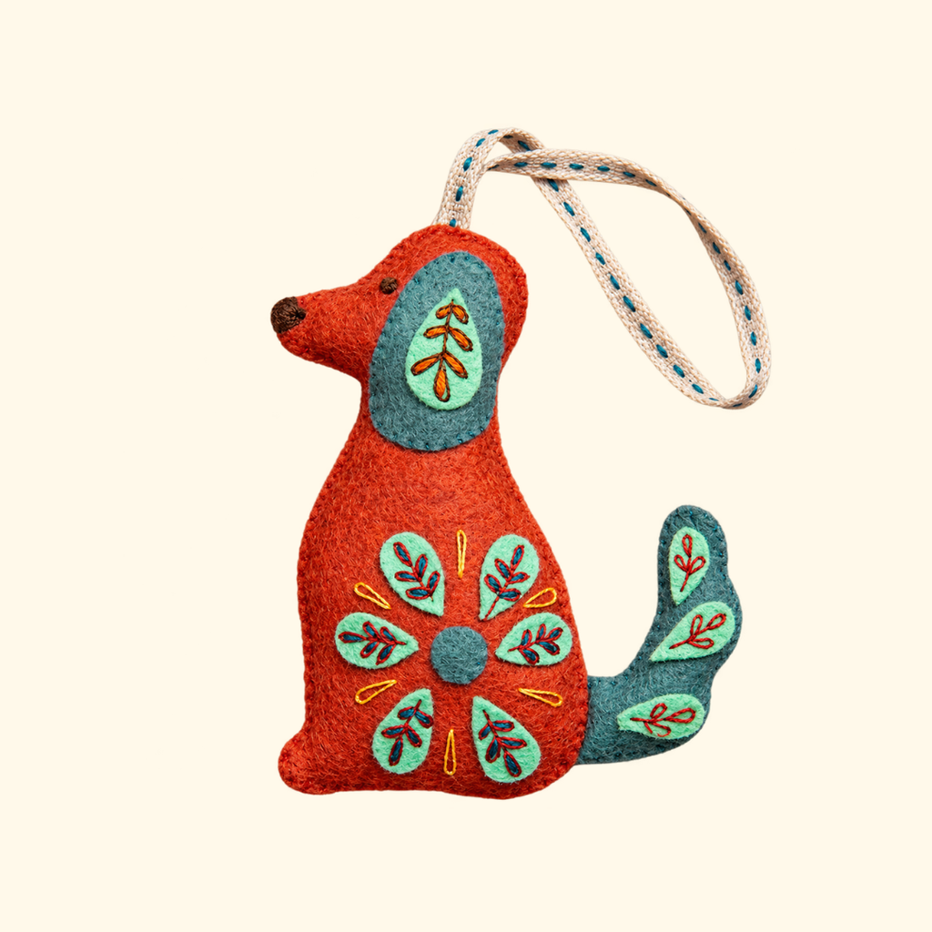 Completed burnt orange felt dog ornament with teal ears, colourful folk embroidery and hanging loop.