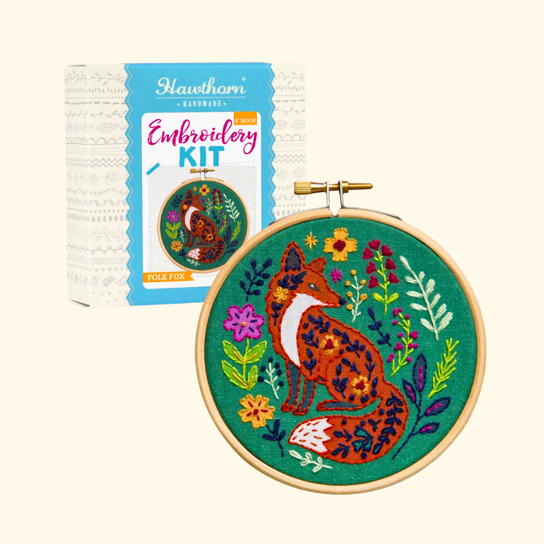 Folk Fox Mini Embroidery Kit by Hawthorn Handmade with the presentation box beside the finished embroidery hoop.