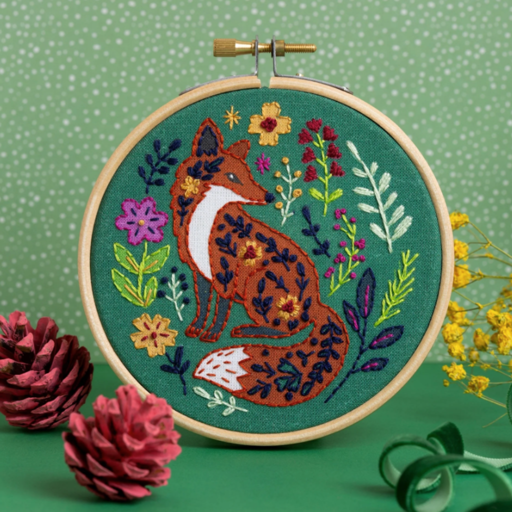 Finished Folk Fox embroidery hoop displayed with seasonal decorative props.