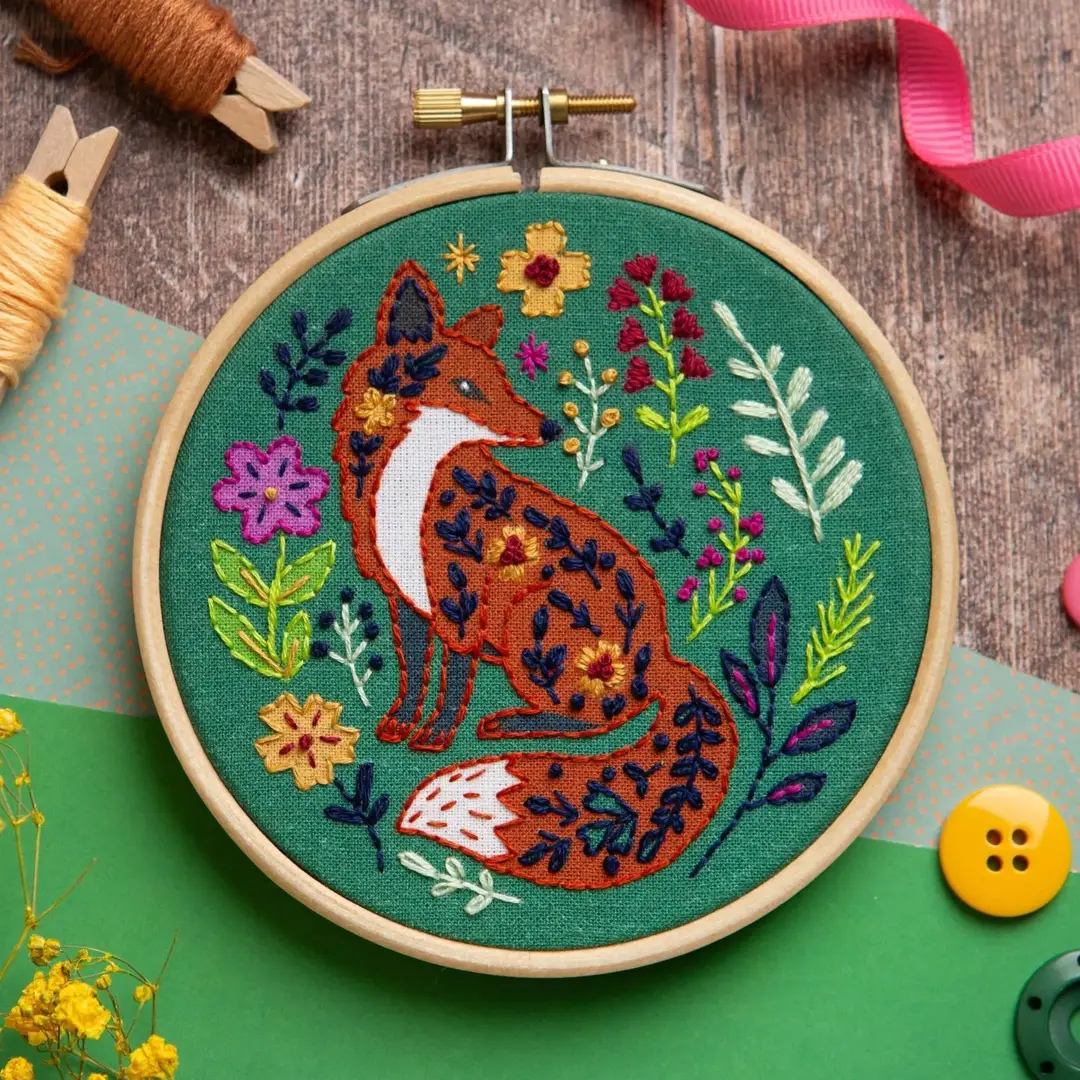 Folk Fox Mini Embroidery Kit by Hawthorn Handmade with the finished embroidery hoop displayed on a crafting surface.