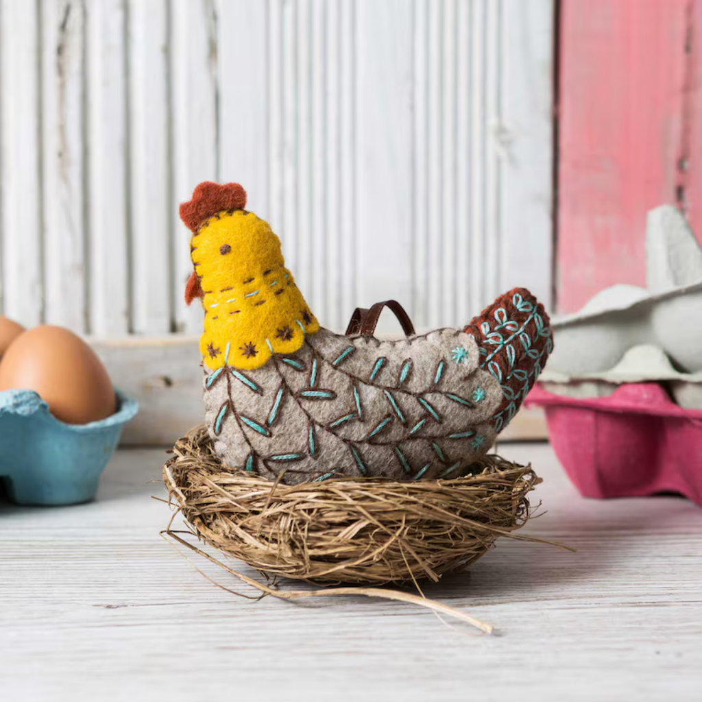 Finished French Hen felt craft kit by Corinne Lapierre displayed in a woven basket within a styled kitchen setting.