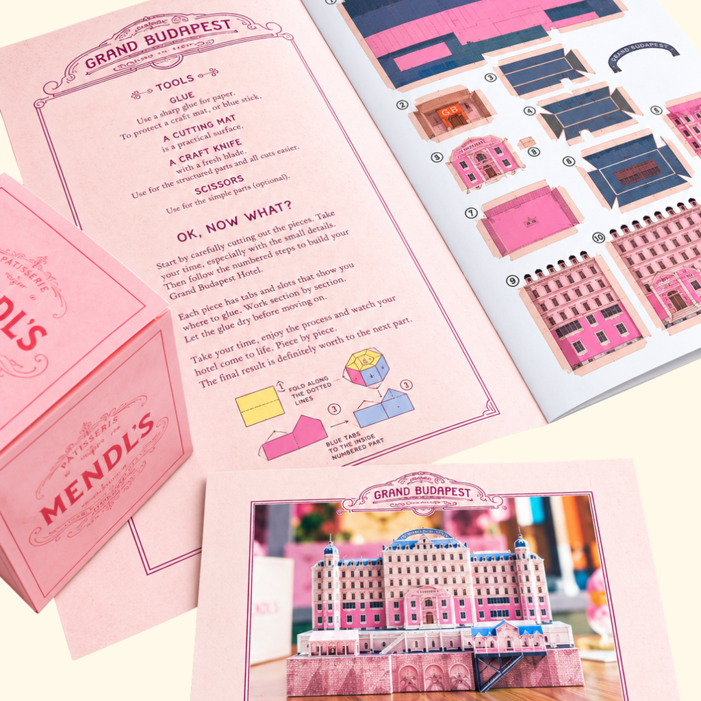 Grand Budapest Hotel DIY paper craft kit showing illustrated assembly instructions, colourful cardstock pieces and packaging inspired by Wes Anderson's film.