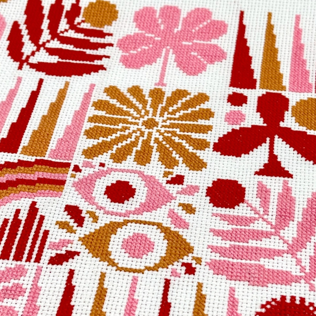 Detailed view of the Harvest Grid cross stitch pattern highlighting colourful botanical motifs and geometric embroidery.