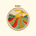 Harvest Time Mini Embroidery Kit by Hawthorn Handmade featuring colourful rolling fields, patchwork farmland and a golden countryside landscape.