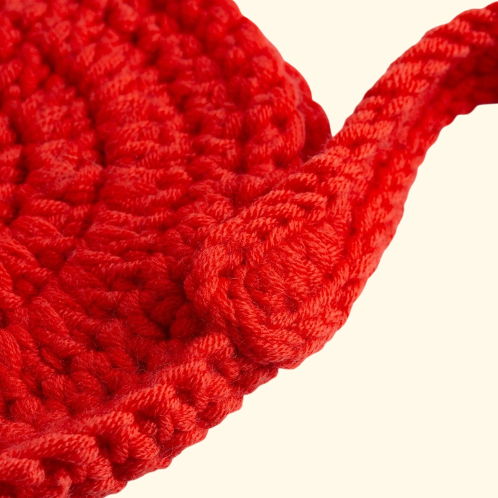 Close up of the completed heart shaped crochet bag showing the textured crochet stitches.