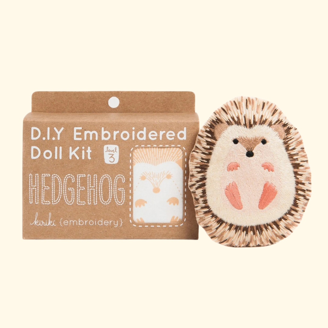 Kiriki Press Hedgehog Embroidery Kit shown with the finished embroidered hedgehog doll and DIY kit packaging.
