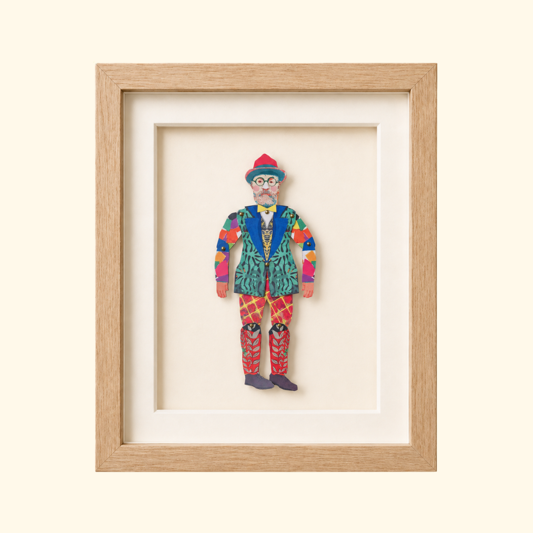 Framed Henri Matisse paper puppet wearing a colourful patterned suit and red hat.
