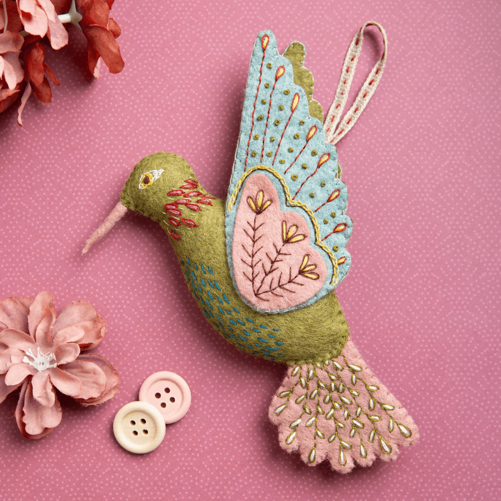 Completed hummingbird ornament from the Hummingbird Felt Craft Kit by Corinne Lapierre displayed with decorative buttons and floral accents.