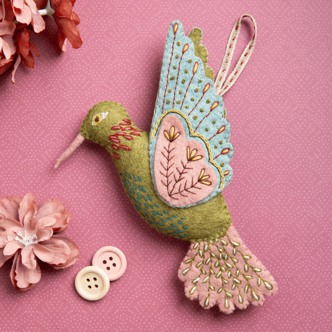 Completed hummingbird ornament from the Hummingbird Felt Craft Kit by Corinne Lapierre displayed with decorative buttons and floral accents.