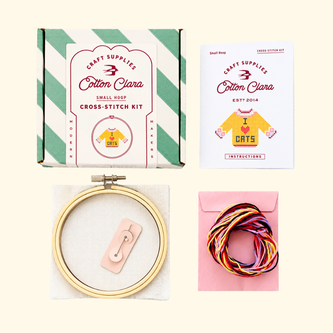Contents of the Cotton Clara I Love Cats Cross Stitch Kit including bamboo hoop, Aida fabric, colourful embroidery threads, needle and instructions.