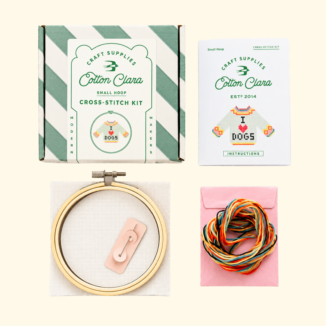 Contents of the Cotton Clara I Love Dogs Cross Stitch Kit including bamboo hoop, Aida fabric, colourful embroidery threads, needle and instructions.