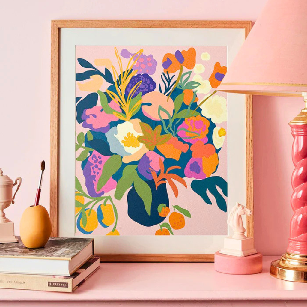 Framed In Bloom paint by numbers artwork styled on a shelf beside books and decorative objects