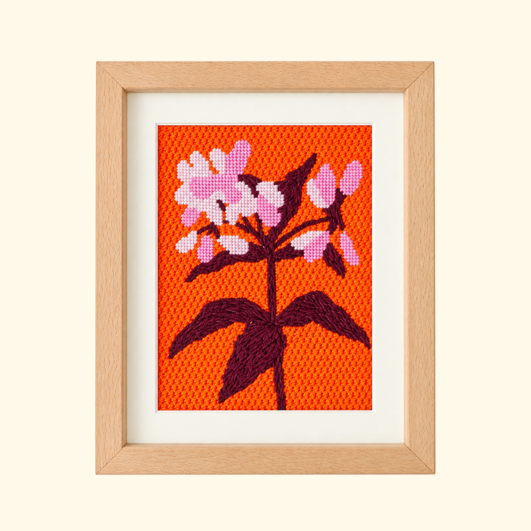 Finished Joe Pye Weed Needlepoint Kit by Unwind Studio featuring pink flowers on an orange background