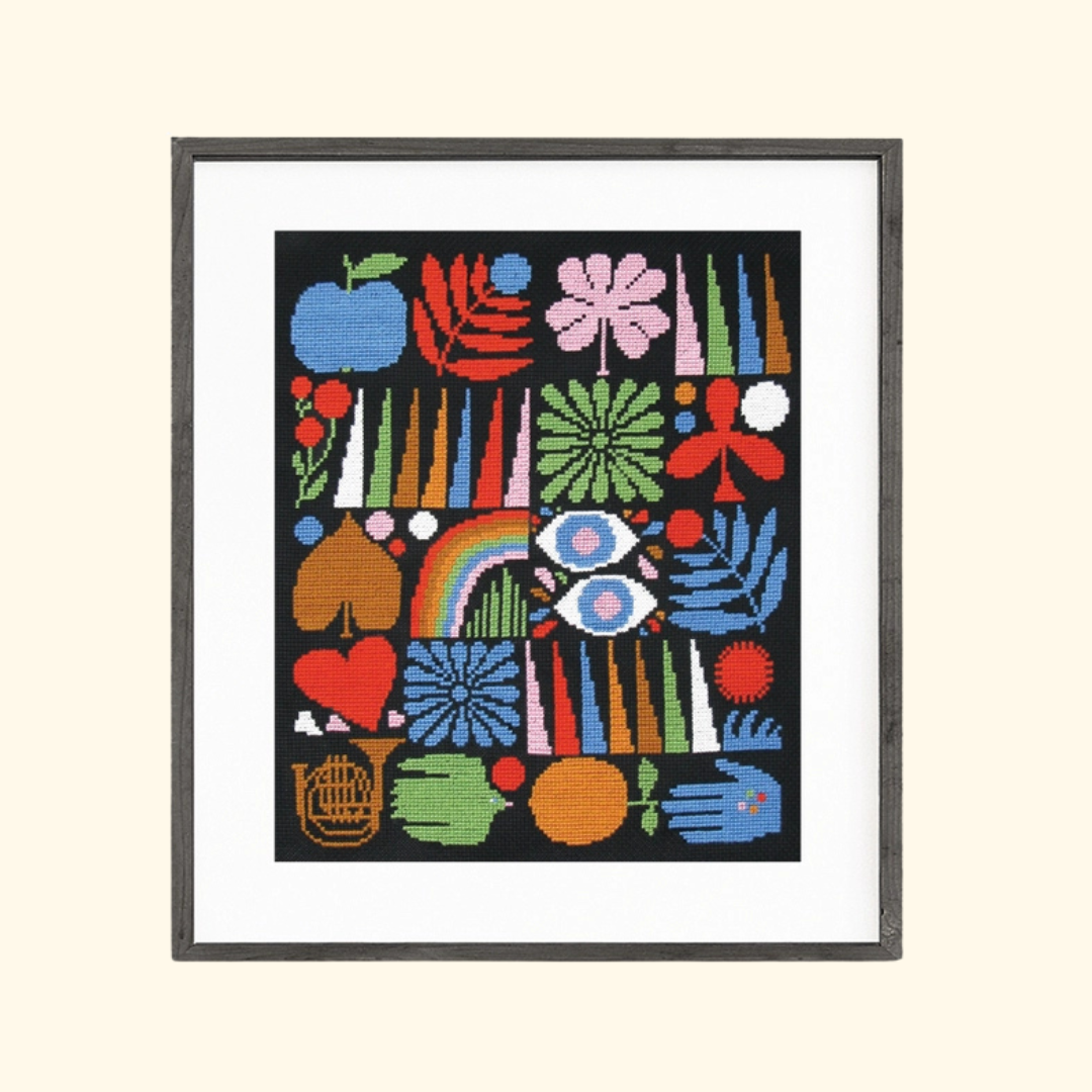 Finished Joyful Grid cross stitch featuring a colourful botanical design in a black frame.