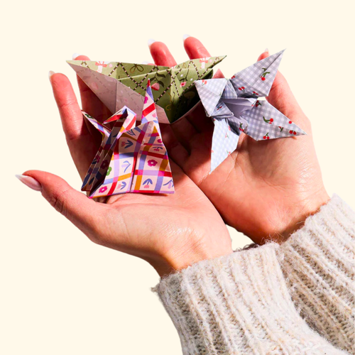 Hand holding completed origami creations made from the Kitsch Patterns Origami Set