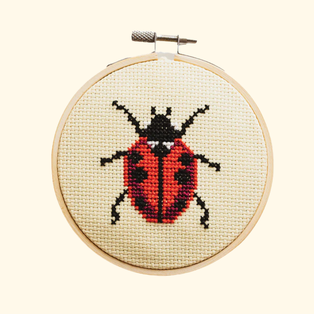 Completed ladybird cross stitch design stitched in a bamboo embroidery hoop by Cotton Clara.