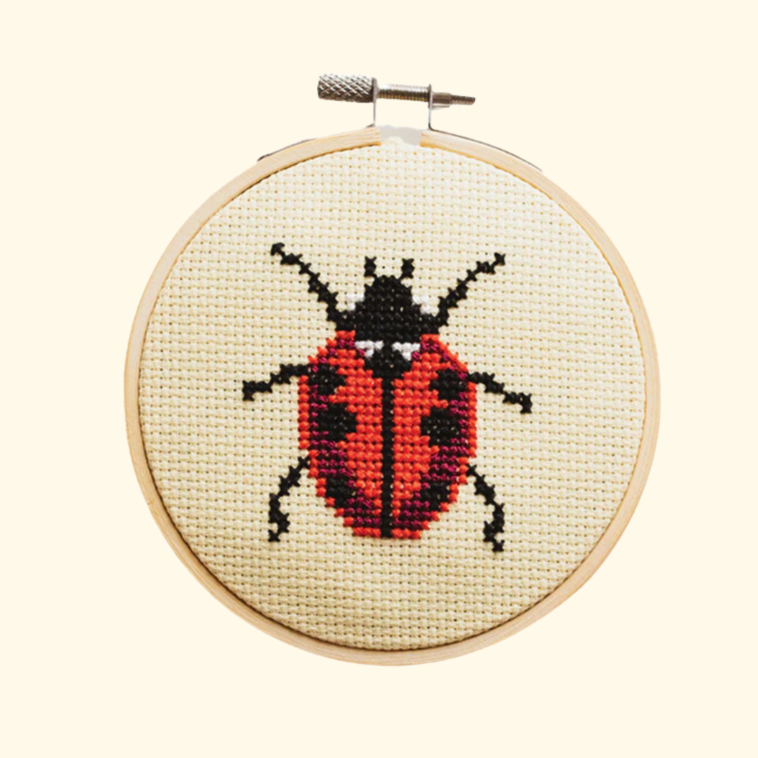 Completed ladybird cross stitch design stitched in a bamboo embroidery hoop by Cotton Clara.