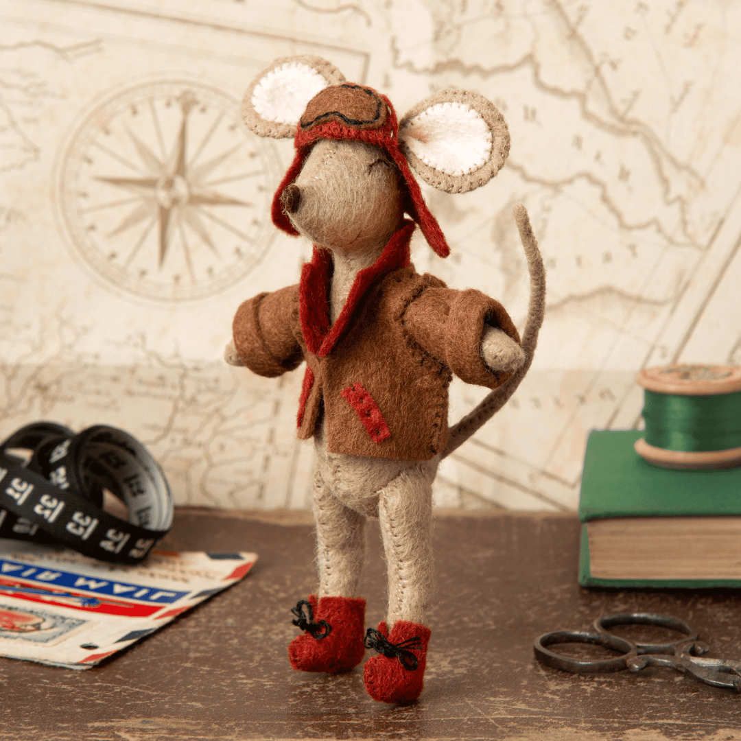 Finished Little Mouse Aviator felt mouse displayed on a desk with vintage travel-inspired accessories.